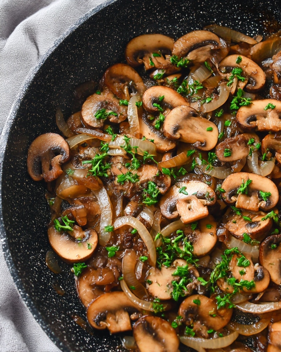 A white oval dish filled with cooked mushroom slices and soft cooked onion slices mixed together, showing a shiny, slightly oily texture. The mushrooms are brown with some darker spots, while the onions are translucent and light golden. Bright green chopped parsley is sprinkled evenly on top, adding a fresh breath of color. The dish is placed on a wooden board with a grey cloth in the background, all set on a white marbled surface. photo taken with an iphone --ar 4:5 --v 7
