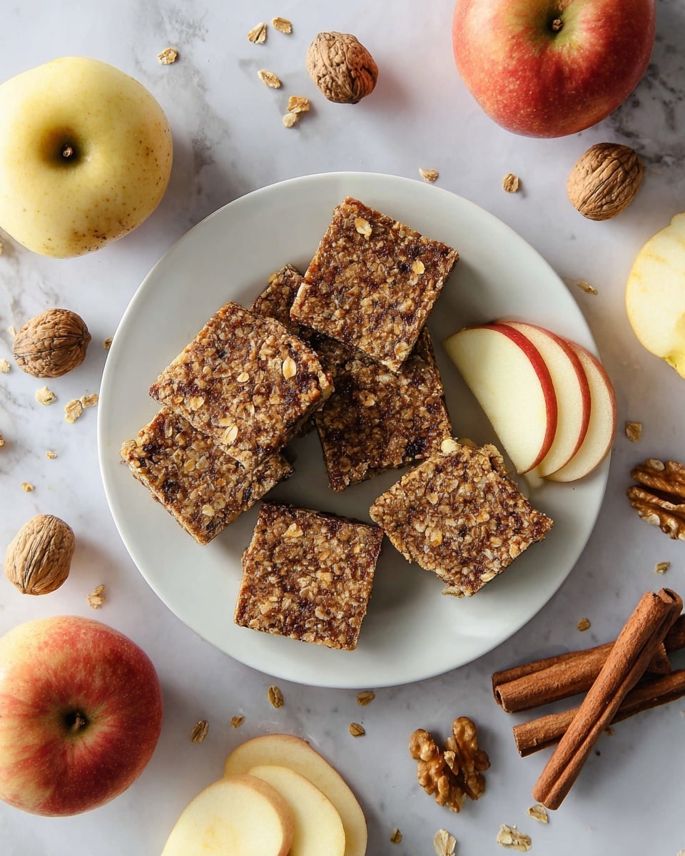 A white plate sits on a white marbled surface, holding five square oat and nut bars that are brown with a rough texture showing oats and pieces of nuts, stacked slightly unevenly. Two thin pale cream apple slices with red edges rest on the plate near the bars. Surrounding the plate are whole and halved apples with a yellow-red skin, some walnut halves, and two cinnamon sticks, all arranged casually on the white marbled surface. Photo taken with an iphone --ar 4:5 --v 7