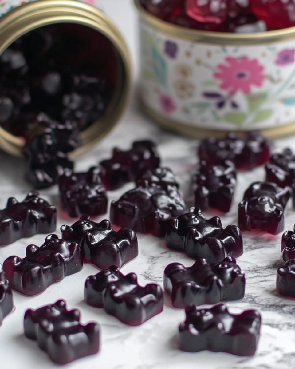The image shows many dark purple gummy candies shaped like bears scattered on a white marbled surface. Each bear candy has a shiny texture and visible details such as small ears and paws. In the background, there is a blurry container with a floral design and a metal lid filled with more candies, some slightly translucent with a deep red color. The overall scene has a soft focus, emphasizing the gummy bears in the middle. photo taken with an iphone --ar 4:5 --v 7