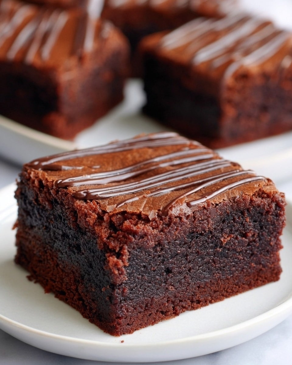 The image shows a close-up of several thick chocolate brownies placed on a white plate with a white marbled background. Each brownie features two main layers: a dense, moist, and dark chocolate base that looks rich and fudgy, and a thinner top layer that is slightly lighter brown and more cake-like, with glossy, dark chocolate drizzle lines running horizontally across the top. The edges of the brownies are crumbly, adding texture contrast. The focus is on one brownie in the front, highlighting its smooth top and textured sides, with other brownies slightly blurred in the background. Photo taken with an iphone --ar 4:5 --v 7
