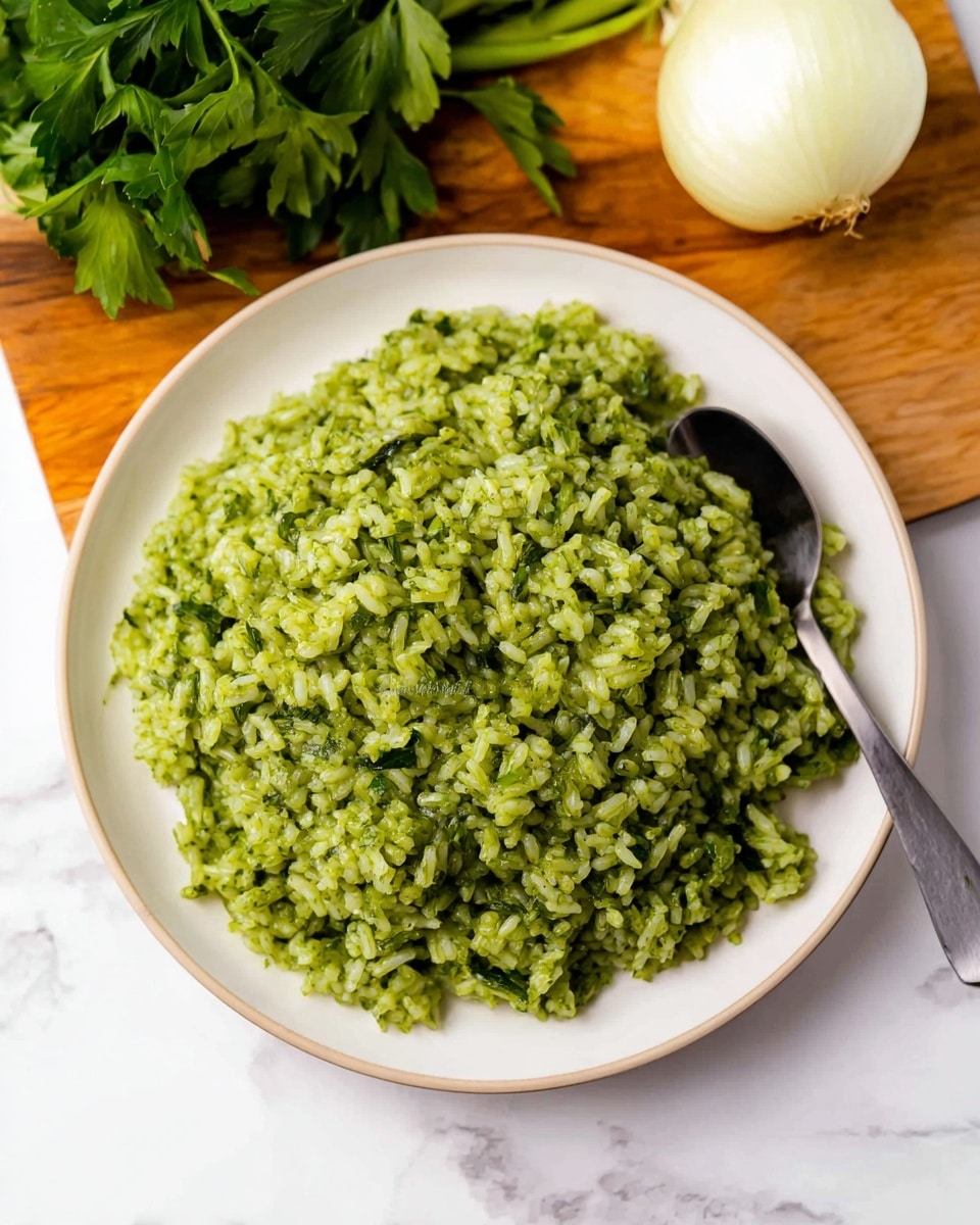 A white plate filled with a mound of green rice, with each grain distinct and coated in a thick green sauce with a slightly chunky texture, piled high in the center. A silver spoon is partially inserted on the right side of the plate. The plate sits on a round wooden board, and in the background, there is a bunch of bright green cilantro and a whole white onion on a white marbled surface. photo taken with an iphone --ar 4:5 --v 7