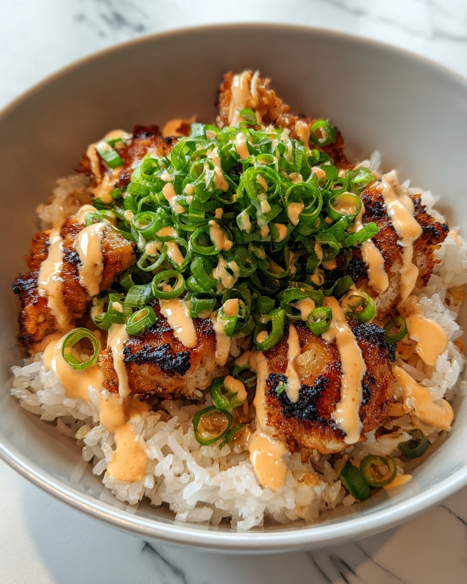 A white bowl holds a base layer of fluffy white rice with some green onion slices scattered on top. Over the rice, there are several pieces of golden-brown fried chicken with a crispy texture and slight charring. Drizzled generously over the chicken pieces is a light orange creamy sauce. The dish is finished with a thick pile of bright green chopped scallions covering the chicken, adding a fresh contrast. The background surface has a white marbled texture. photo taken with an iphone --ar 4:5 --v 7