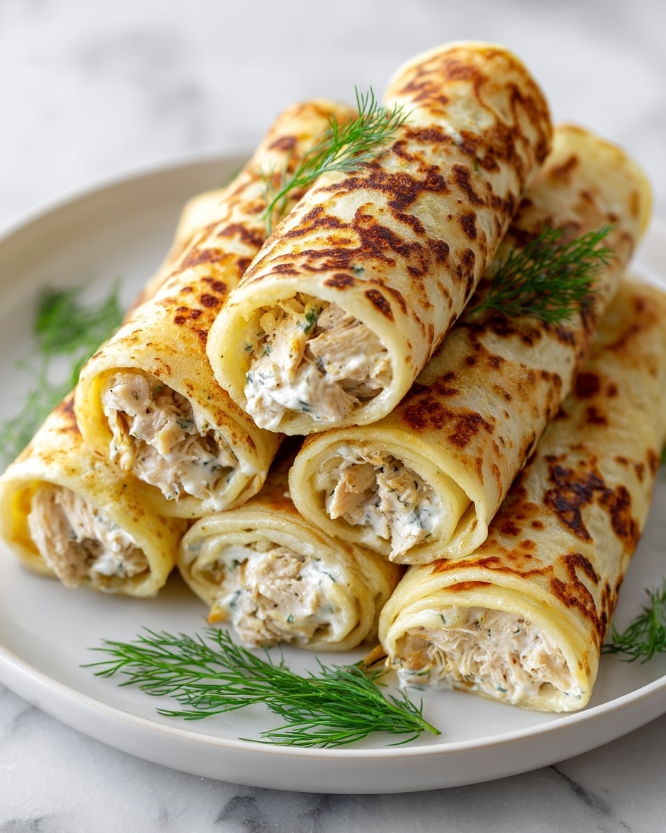 A white plate holds five golden-brown rolled crepes, each filled with a creamy white mixture flecked with green herbs, visible at the open ends. The crepes have a crunchy, lightly browned crust sprinkled with fresh green herbs like dill and chives. Two small white bowls with a creamy white sauce topped with green onion and dill sit on the plate, with a few pickles sliced into rounds placed beside one bowl. Fresh dill sprigs and chopped green onions are scattered around the plate, which rests on a white marbled textured surface. photo taken with an iphone --ar 4:5 --v 7